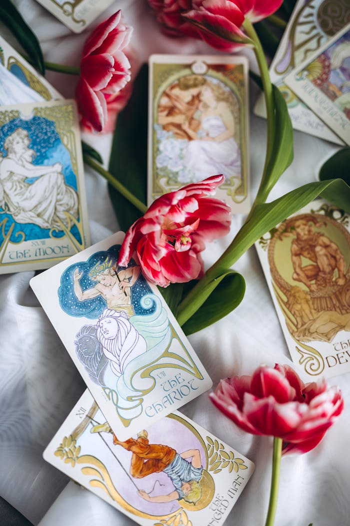 A striking arrangement of tarot cards and red tulips on a soft background, creating a mystical atmosphere.
